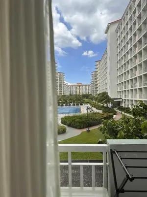 a balcony with a view of a pool and buildings at Eu & El Condo in Manila
