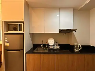 a small kitchen with a sink and a refrigerator at Eu & El Condo in Manila