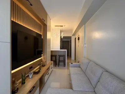 a living room with a couch and a flat screen tv at Eu & El Condo in Manila