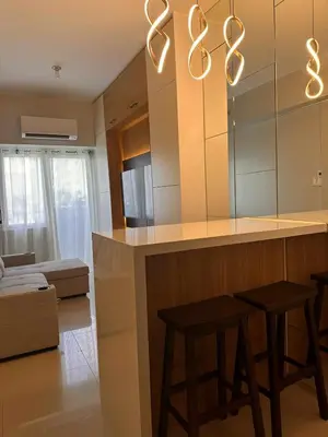 a kitchen with two stools and a bar with a mirror at Eu & El Condo in Manila