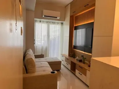 a living room with a couch and a television in a room at Eu & El Condo in Manila