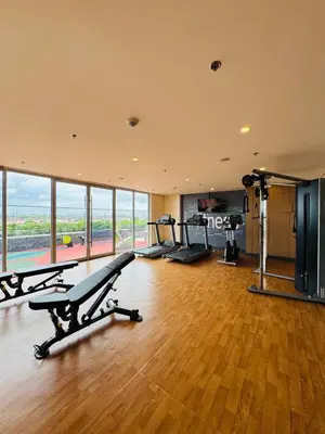 a gym with treadmills and ellipticals in a room with wood floors at Maple Grove Yasuragi Stay in General Trias