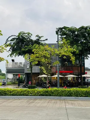 a building with trees in front of a street at Maple Grove Yasuragi Stay in General Trias