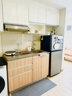 a kitchen with white cabinets and a refrigerator at Maple Grove Yasuragi Stay in General Trias