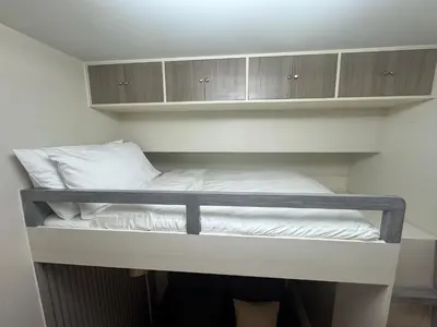 a bunk bed in a room with wooden cabinets at JUANderful Home at Park McKinley West in Manila