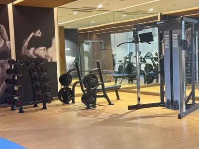 a gym with a bunch of equipment in a room at JUANderful Home at Park McKinley West in Manila