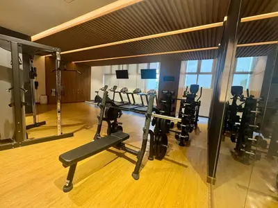 a gym with a row of treadmills and machines at JUANderful Home at Park McKinley West in Manila