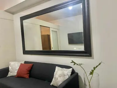 a mirror above a couch in a living room at Sea Residences Tower F in Manila