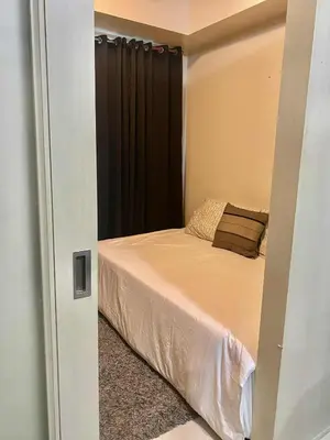 a bedroom with a bed with a black curtain at Sea Residences Tower F in Manila