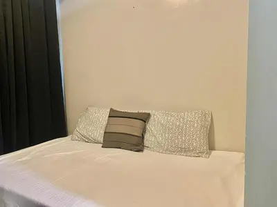 a bed with two pillows on top of it at Sea Residences Tower F in Manila