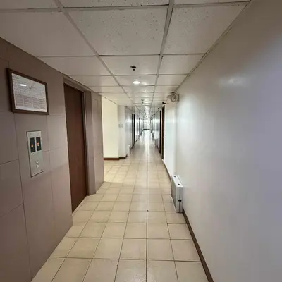 an empty corridor in an office building with a long hallway at Isabelle Garden Hotel & Suites in Manila