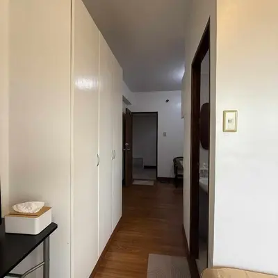 a hallway with white walls and wooden floors in a room at Isabelle Garden Hotel & Suites in Manila