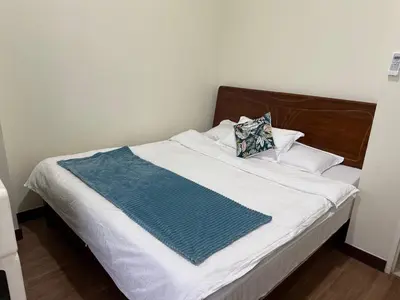 a bed with a blue and white blanket on it at fairlane residences in Manila