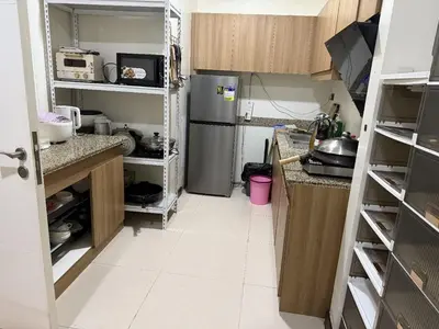 a kitchen with a refrigerator and a white tile floor at fairlane residences in Manila