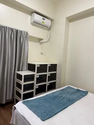 a bedroom with a bed and a air conditioner at fairlane residences in Manila