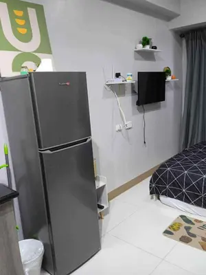 a kitchen with a refrigerator in a room at Modern Comfort in Pasay with Pool in Manila