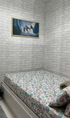 a bed in a bedroom with a painting on the wall at Modern Comfort in Pasay with Pool in Manila