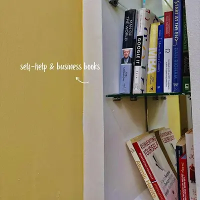 a book shelf filled with books next to a wall at JAZZ staycation in Manila
