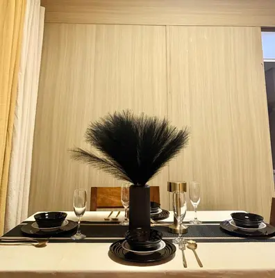 a table with glasses and a vase with a plant on it at COAST518 Pasay in Manila