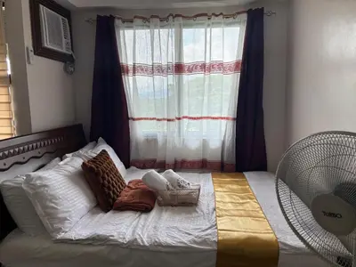 a bedroom with a large bed with a window at Dainty Den LF508 - Comfy & Chic Home beside Enchanted Kingdom in Santa Rosa