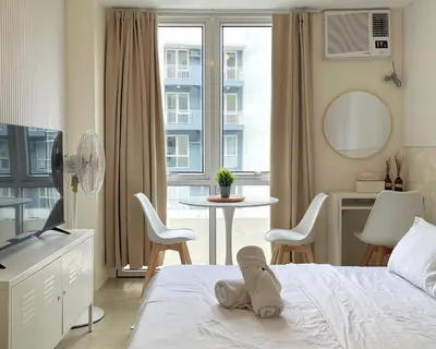 a bedroom with a bed and a table and chairs at City View Condo in Pasig with Pool, WiFi and Netflix in Manila