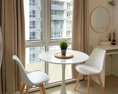 a table and two chairs in a room with a window at City View Condo in Pasig with Pool, WiFi and Netflix in Manila