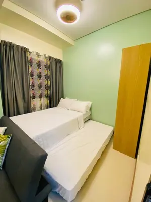 a small room with two beds and a window at S Residences Tower 2, 1 Bedroom in Manila