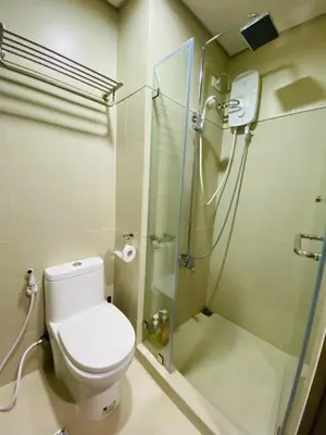 a bathroom with a toilet and a glass shower at S Residences Tower 2, 1 Bedroom in Manila