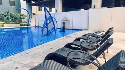 a row of chairs sitting next to a swimming pool at S Residences Tower 2, 1 Bedroom in Manila