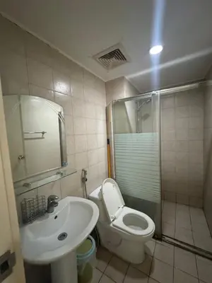a bathroom with a toilet and a sink and a shower at SOHO Central Condotel in Manila