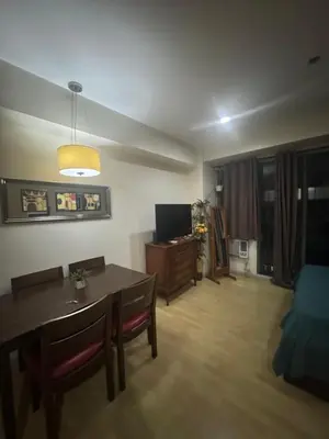 a living room with a dining table and a television at SOHO Central Condotel in Manila