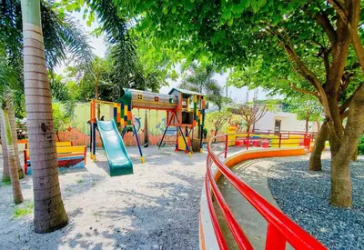 a playground with a slide in a park with trees at The Stayhaus by Dan & Steph in Manila