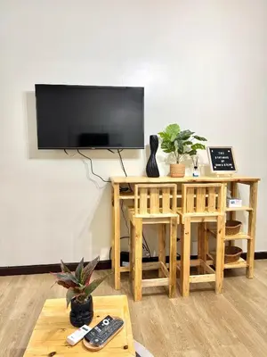 a living room with a flat screen tv on a wall at The Stayhaus by Dan & Steph in Manila