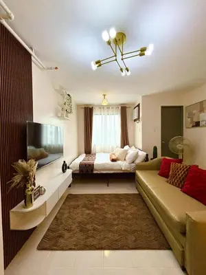 a living room with a bed and a couch at Dainty Den Renovation in Macabling