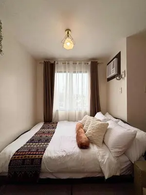 a bedroom with a large bed with a window at Dainty Den Renovation in Macabling