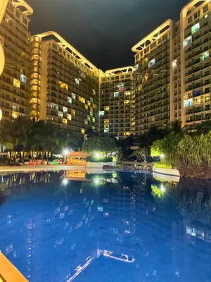 a large swimming pool in front of a large building at Azure Paris Hilton Resort and hotel 1 bedroom for 4pax in Manila