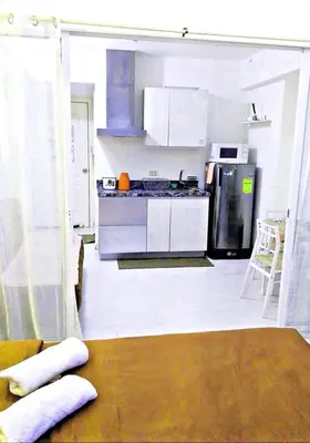 a kitchen with white cabinets and a table and a stove at Azure Paris Hilton Resort and hotel 1 bedroom for 4pax in Manila