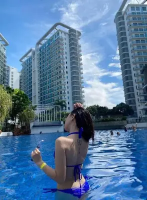 a woman in a bikini in a swimming pool at Azure Paris Hilton Resort and hotel 1 bedroom for 4pax in Manila