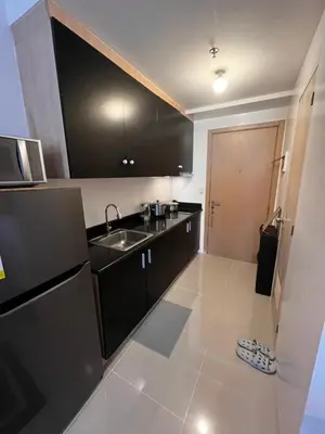 a kitchen with black cabinets and a sink at Light Lux in Manila