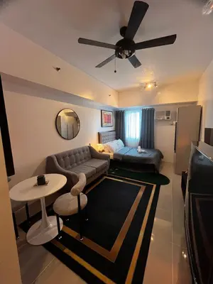 a living room with a couch and a ceiling fan at Light Lux in Manila
