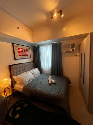 a bedroom with a bed with a teddy bear on it at Light Lux in Manila