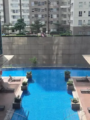 a large blue swimming pool in a building at Modern BGC One Uptown 1BR near Grand Hyatt Uptown Mitsukoshi Malls and St Lukes Medical Center in Manila