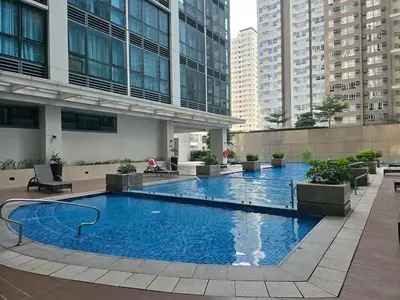 a large swimming pool in the middle of a building at Modern BGC One Uptown 1BR near Grand Hyatt Uptown Mitsukoshi Malls and St Lukes Medical Center in Manila