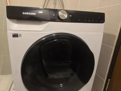 a white washing machine with a black door at Modern BGC One Uptown 1BR near Grand Hyatt Uptown Mitsukoshi Malls and St Lukes Medical Center in Manila