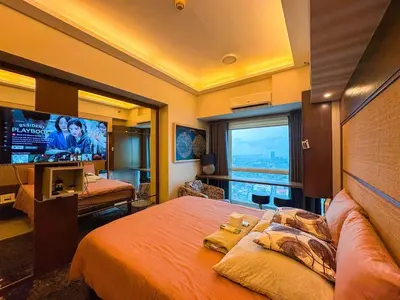 a bedroom with a large bed and a television at City View Unit near Makati CBD in Manila