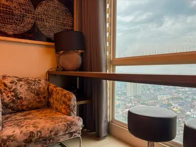 a living room with a chair and a large window at City View Unit near Makati CBD in Manila