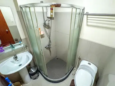 a bathroom with a shower and a toilet and a sink at City View Unit near Makati CBD in Manila
