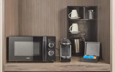 a microwave and a radio on a wooden shelf at Belmont Hotel Manila near NAIA Terminal 3 MNL in Manila