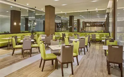 a dining room with tables and chairs in a restaurant at Belmont Hotel Manila near NAIA Terminal 3 MNL in Manila