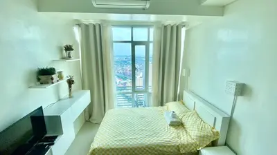 a bedroom with a bed and a large window at Affordable Nordic Style Condo in Makati in Manila